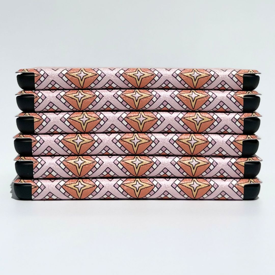 Detail of the pink and terracotta celestial pattern on the Celestia Kindle case