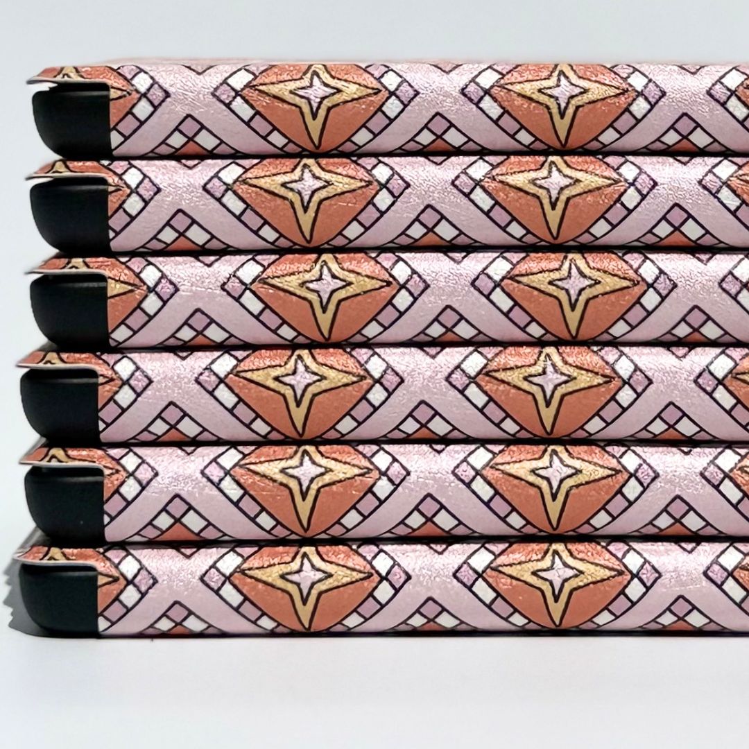 Stacked Celestia Kobo cases angled to show the terracotta and gold star and crescent moon pattern