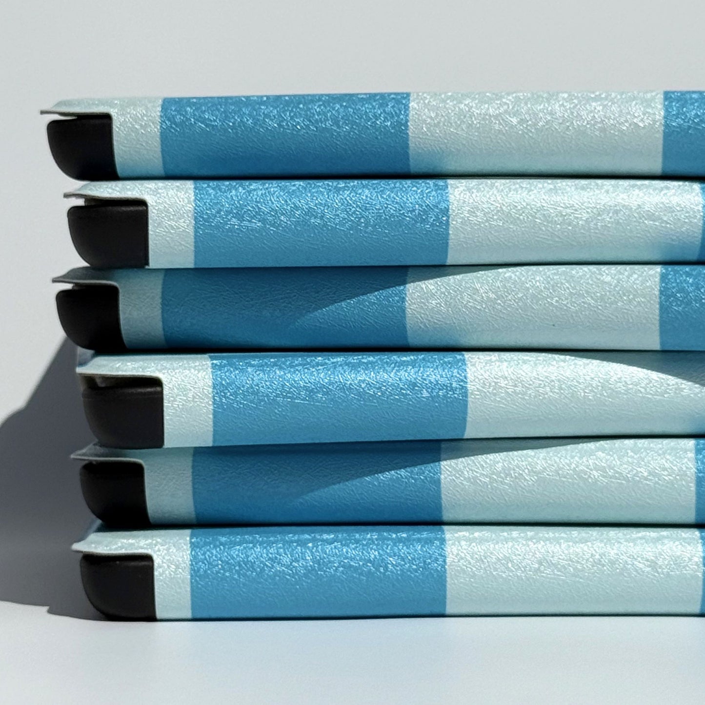 Blue check Kindle cases stacked on their sides showing the folio spine