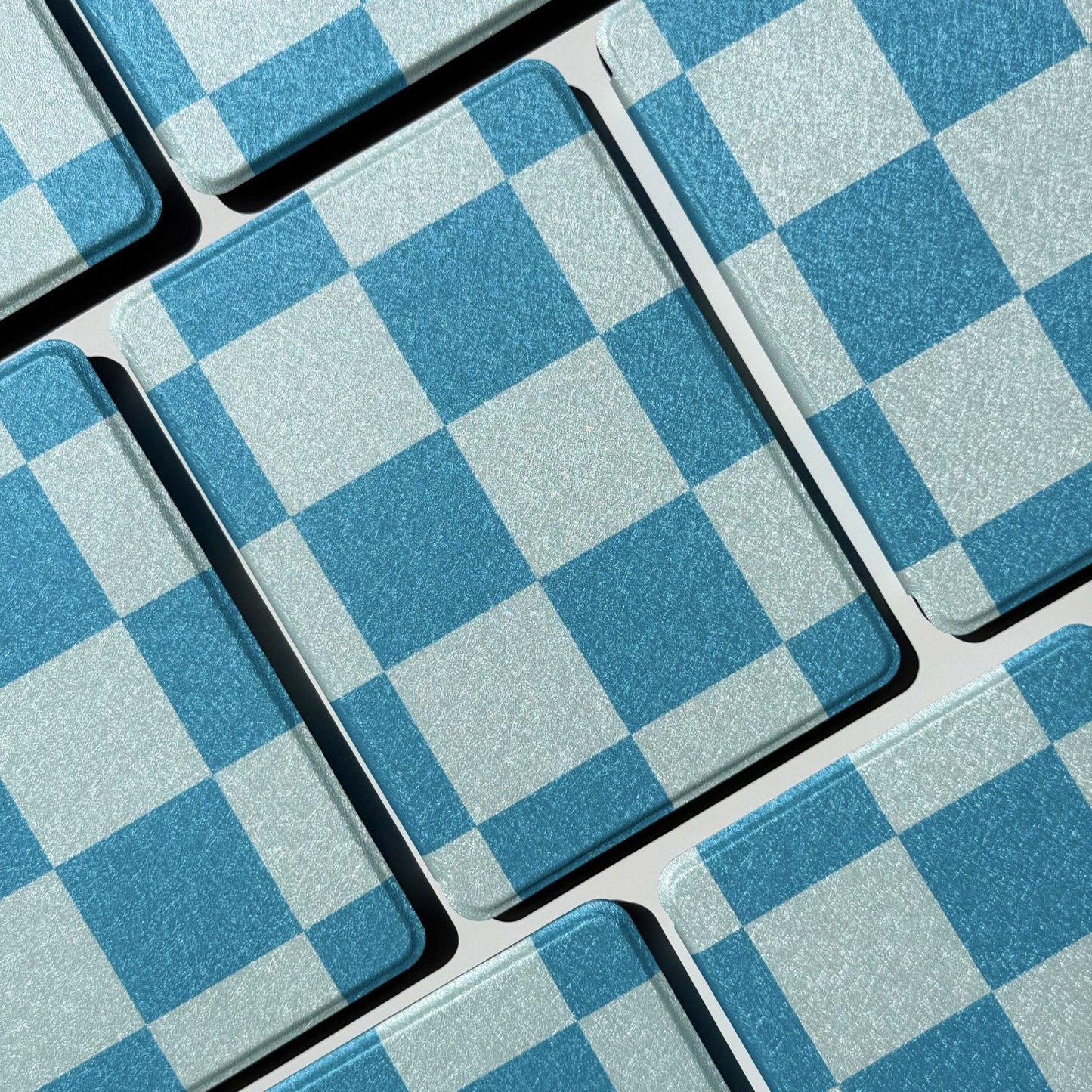Grid of blue gingham Kindle cases in the Cerulean Lore design, Case Society Co