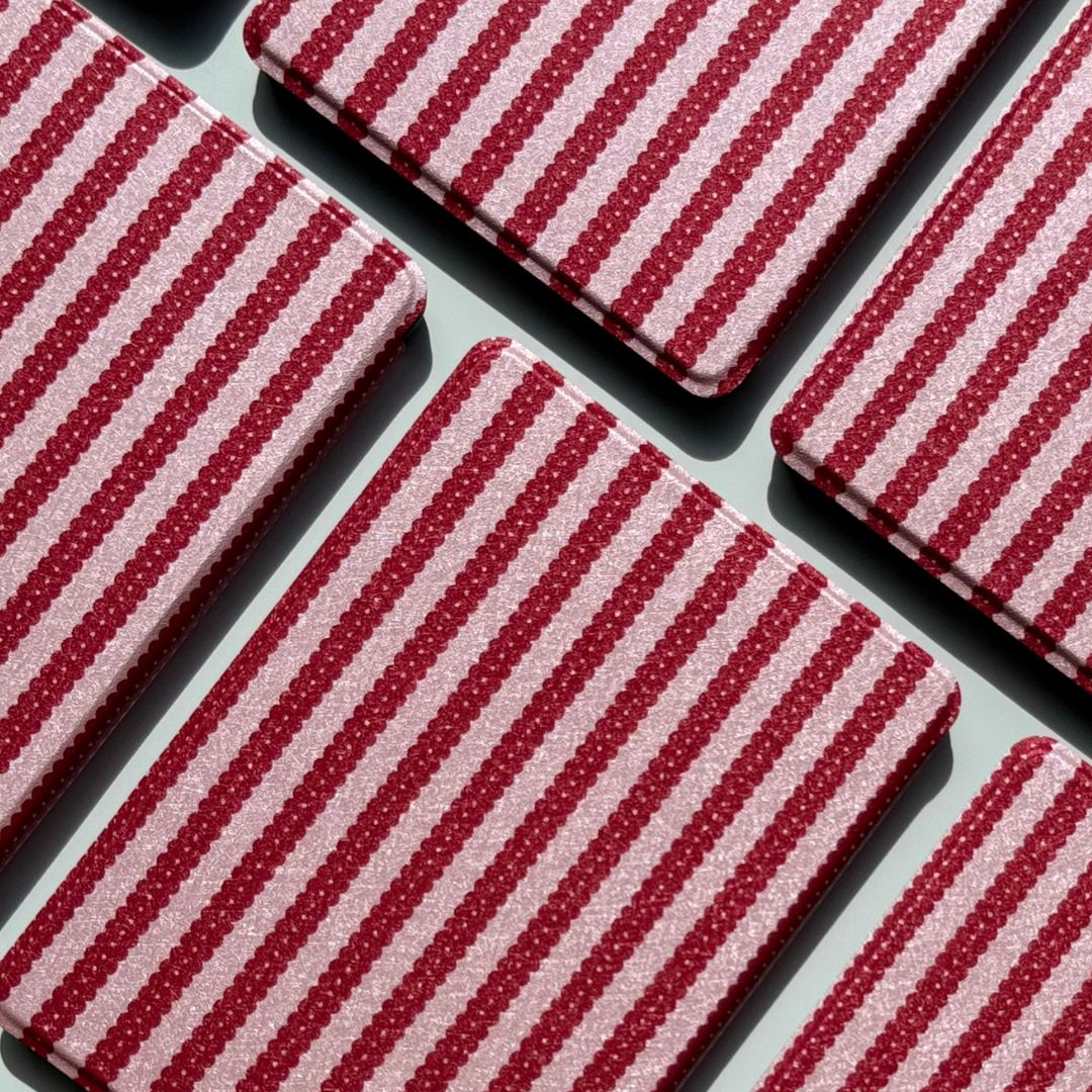 Cherry Ledger Kindle cases from Case Society Co laid out in a diagonal grid in bright sunlight.