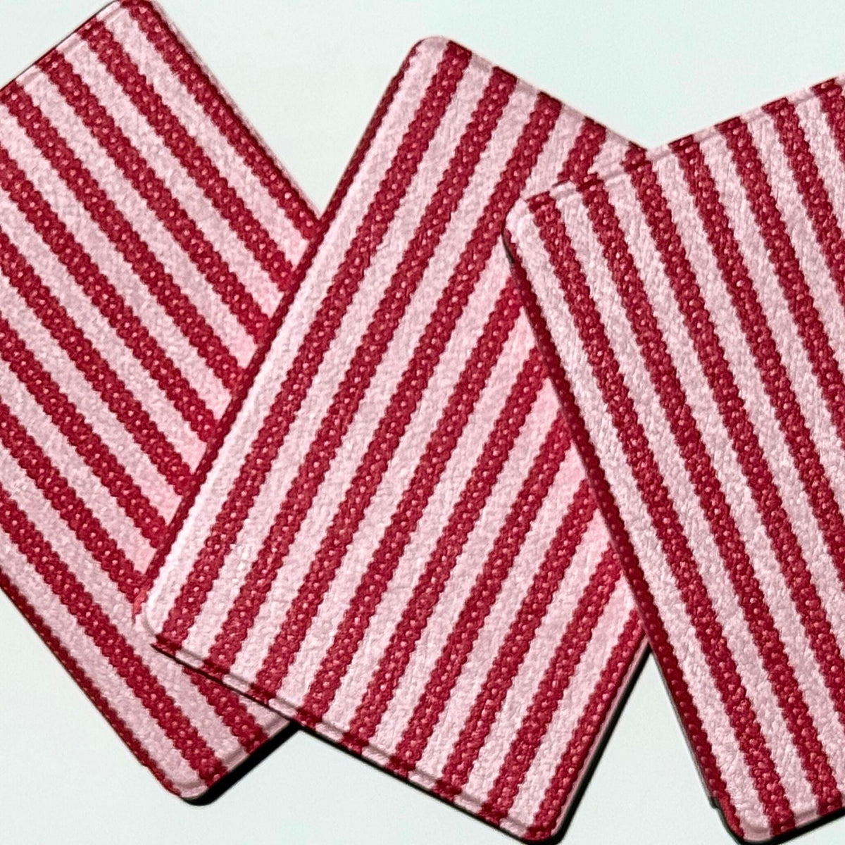 Close-up of the scalloped cherry stripe print on overlapping Cherry Ledger Kindle cases, Case Society Co