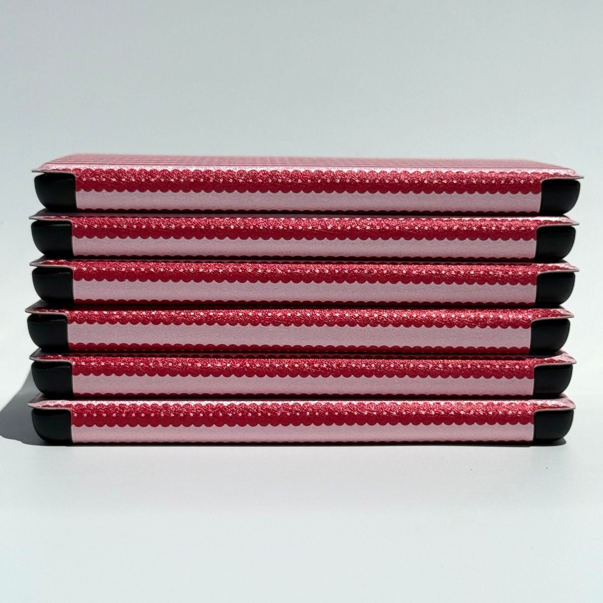 Straight-on stack of Cherry Ledger Kindle cases showing pin-dot cherry stripes, Case Society Australia