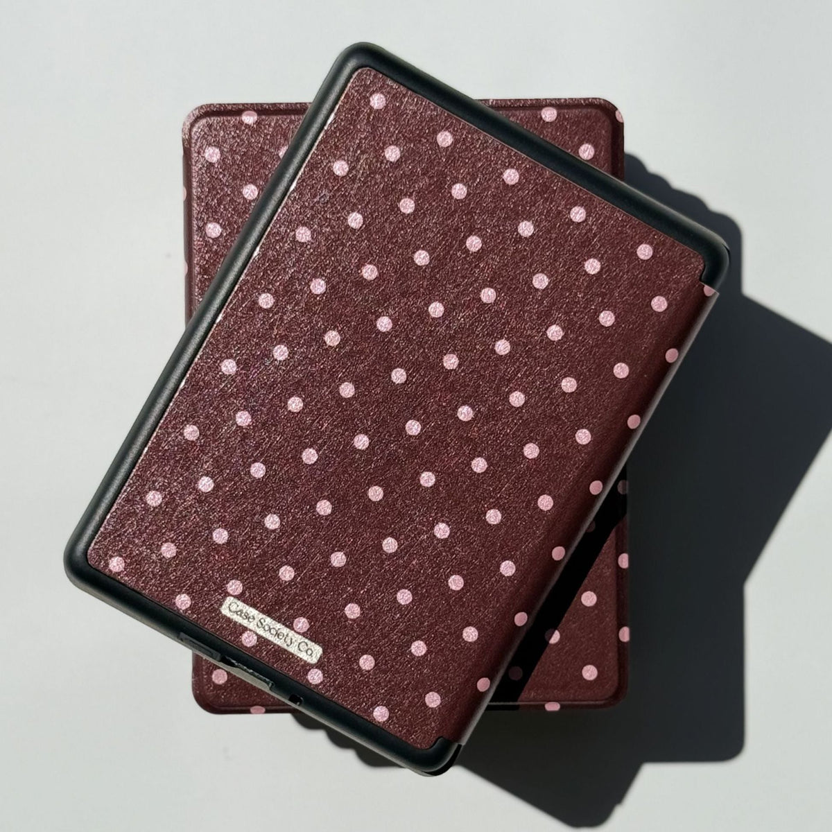 Back of the Cocoa Kiss Kindle case with black frame and silver Case Society Co label on the dotted cover