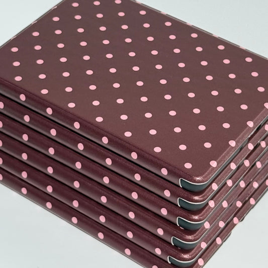 A fanned stack of Cocoa Kiss Kindle cases catching the light, pink dots on chocolate brown