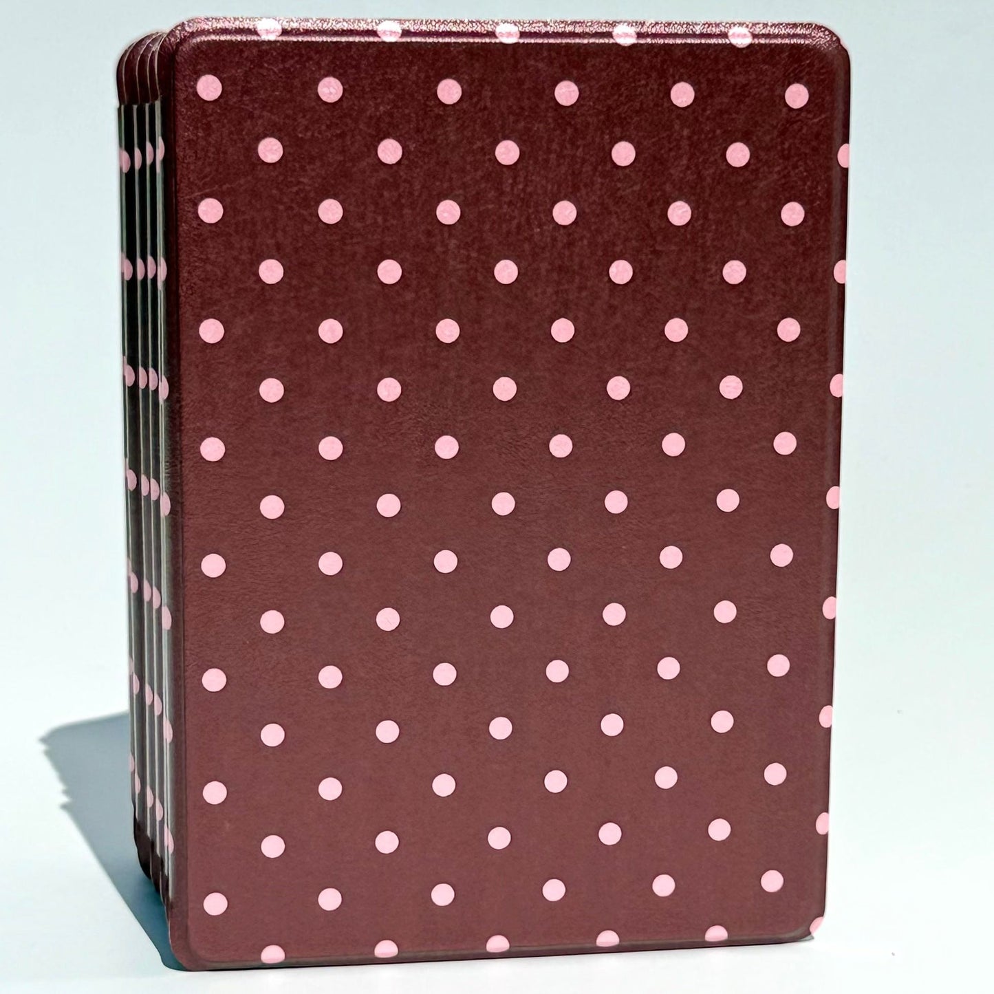 Cocoa Kiss Kindle cases stacked straight on, blush pink polka dots across a rose brown shell