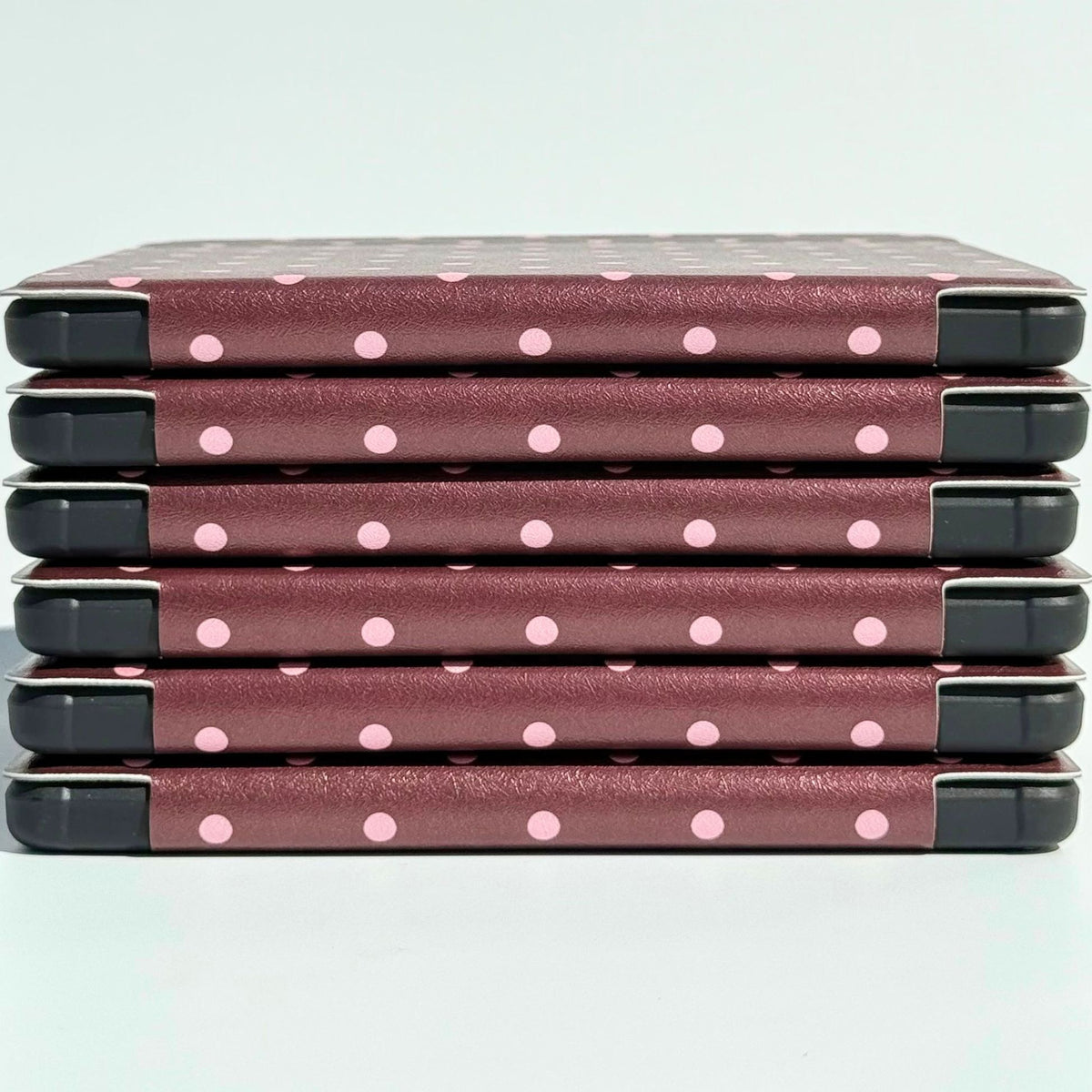 Side view of stacked Cocoa Kiss Kobo Clara cases, slim brown polka dot spines