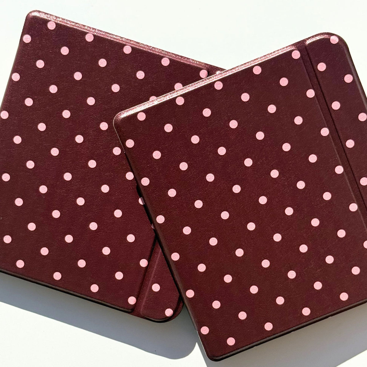 Cocoa Kiss Kobo Libra cases crossed in a flat lay, pink polka dots on cocoa brown