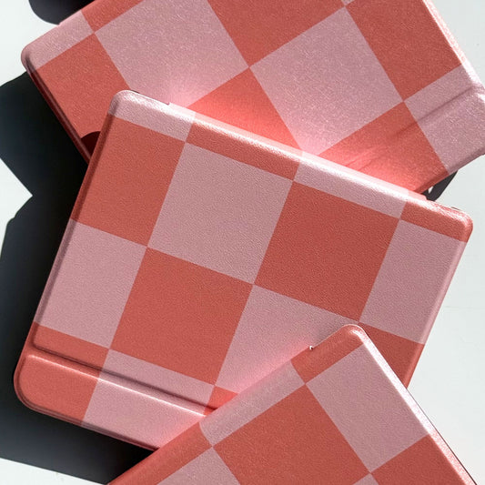 Fairy Tales coral and pink checkerboard Kobo Libra case flat lay — three soft pink and coral check ereader covers on white background