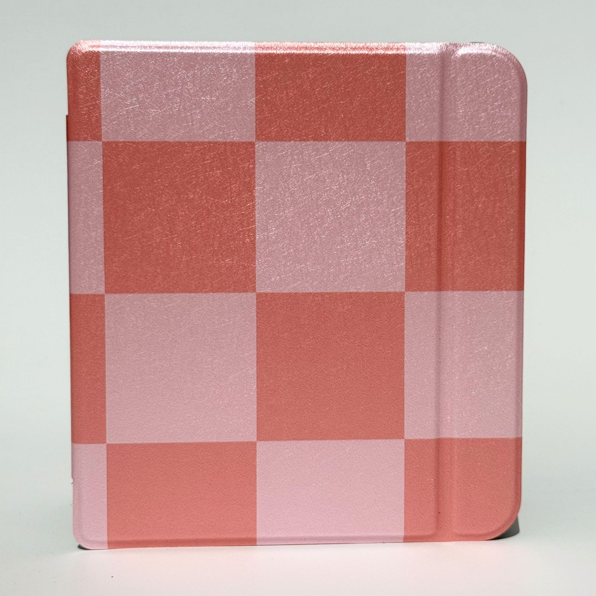 Pair of Fairy Tales Kobo Libra cases stacked at angles, soft pink and coral checkerboard print with coquette aesthetic