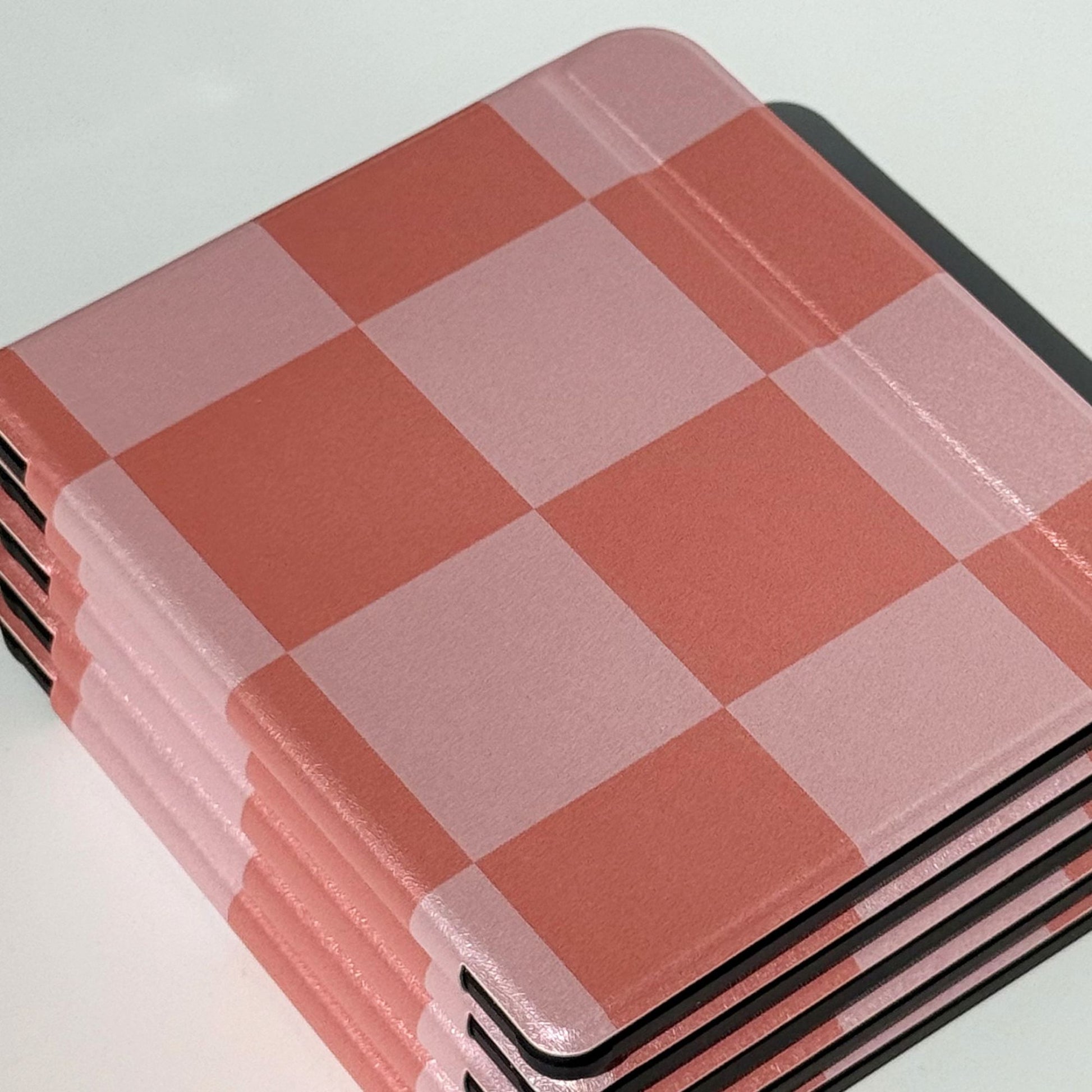 Stacked Fairy Tales Kobo Libra cases viewed from above and side, soft pink and coral large-square check print