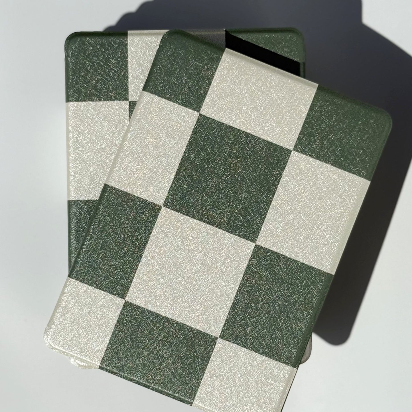 Two Forest Lore green checkered Kindle cases propped to show front and back design