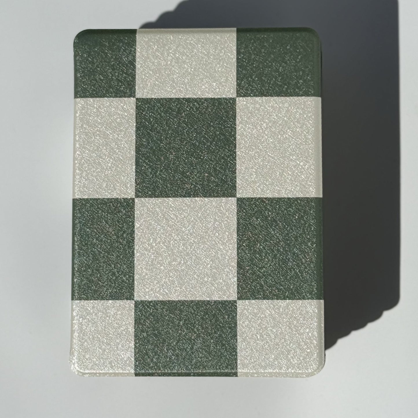 Front of Forest Lore Kindle case showing bold green and cream checkerboard squares with soft shimmer
