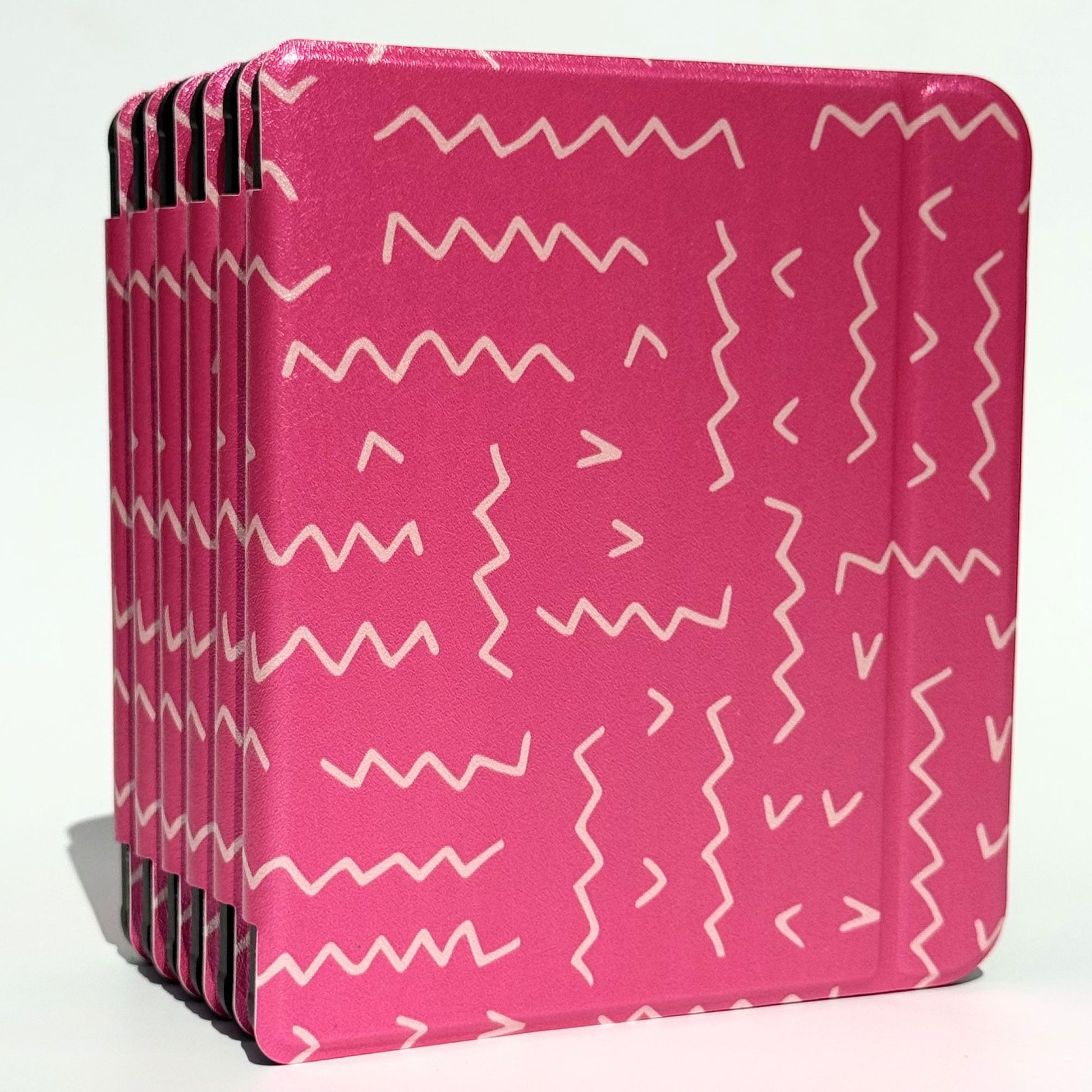 Overlapping flat lay of Literary Lines Kobo Libra cases showing pink aesthetic squiggle ereader cover