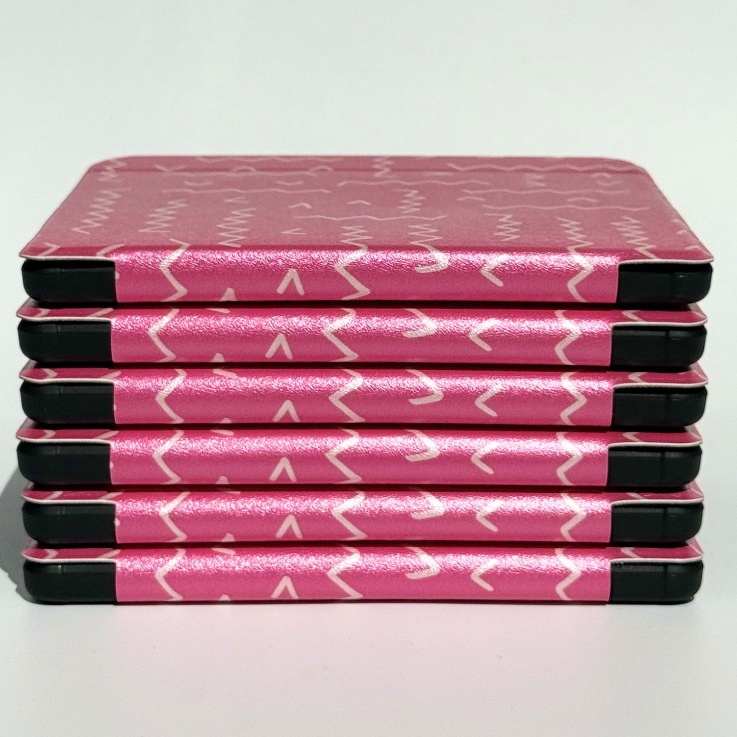 Side profile of Literary Lines Kobo Libra cases stacked, hot pink squiggle print with shockproof black bumper