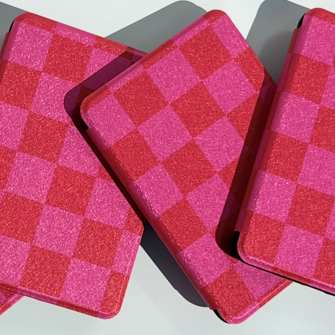 Two pink and red checkered Love's Bouquet Kindle cases overlapping showing checkerboard pattern detail