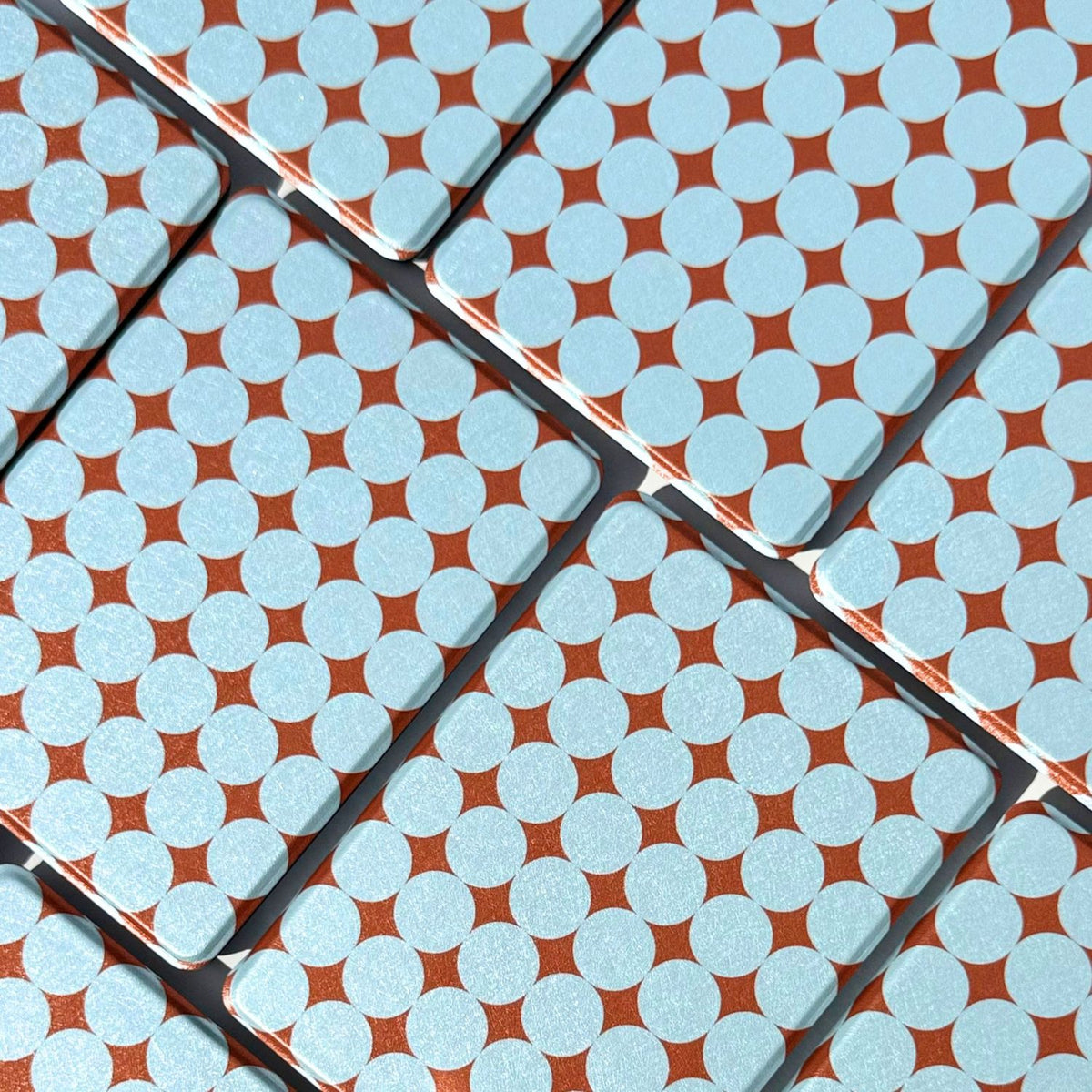 Blue and copper polka dot Kindle cases laid flat in neat rows, Case Society Australia