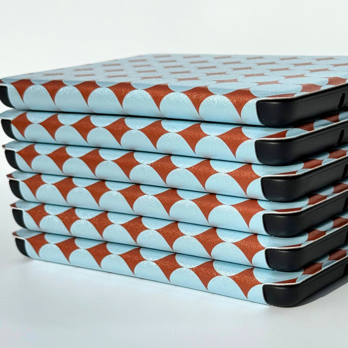 Close-up of the Meet Cute Kindle case corner, pale blue dots over shimmering copper, Case Society Co