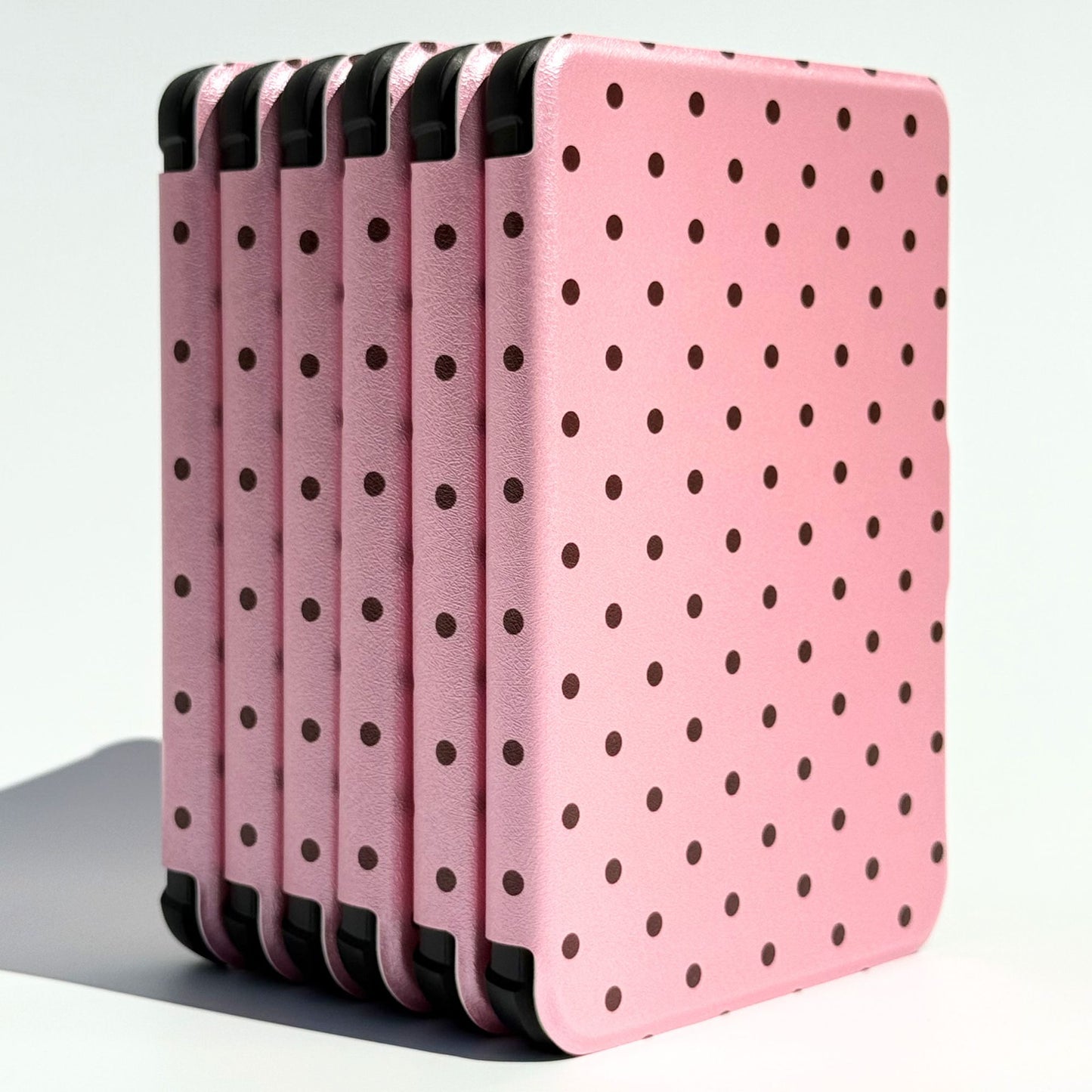 Stack of Pink Reverie Kobo Clara cases, pink polka dot covers with black corner bumpers