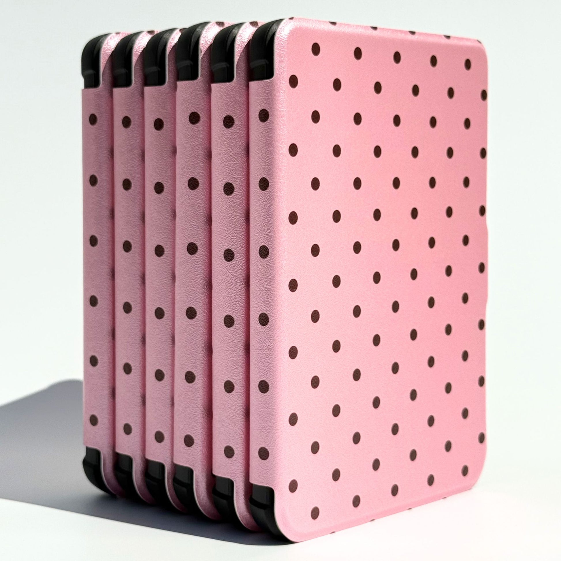 Stack of Pink Reverie Kobo Clara cases, pink polka dot covers with black corner bumpers
