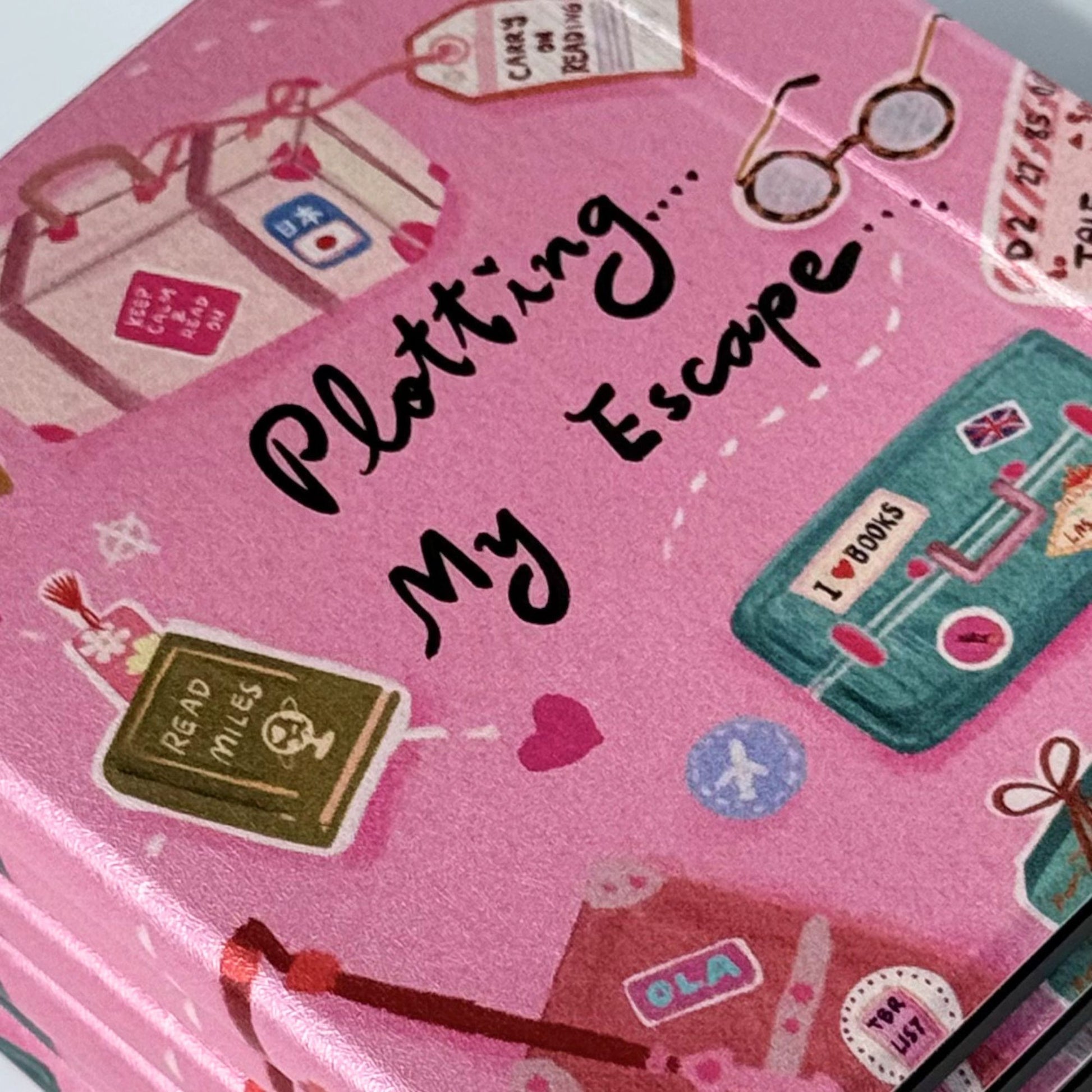 Three Plotting My Escape Kobo Libra cases overlapping showing cute pink ereader cover with books and suitcases