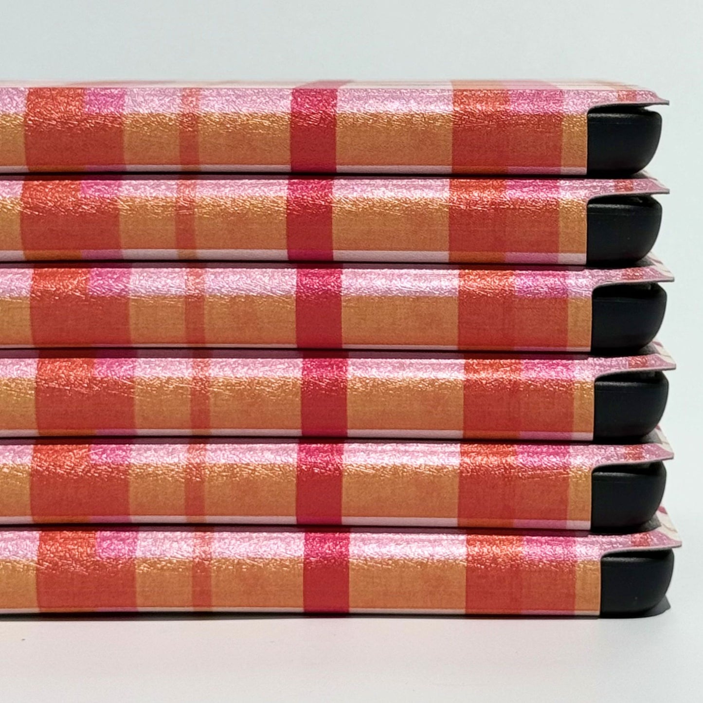 Pink and orange plaid Kindle cases stacked on their sides