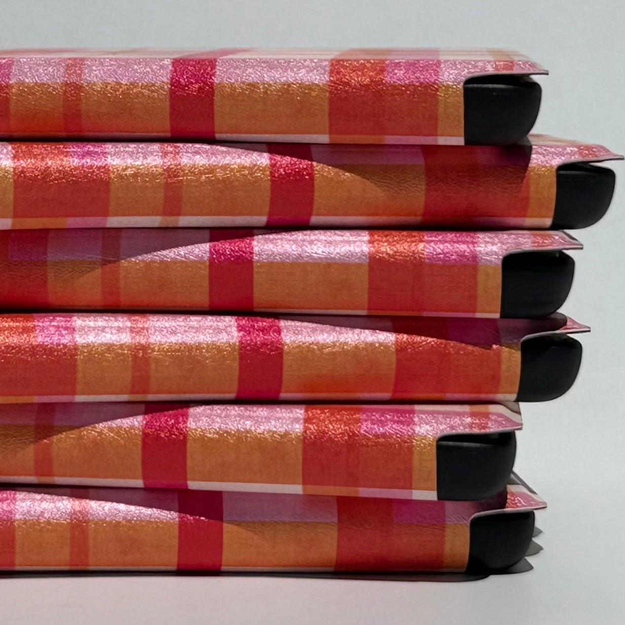 Side stack of Roseline plaid Kindle cases showing shimmer texture and protective corners, Case Society Co