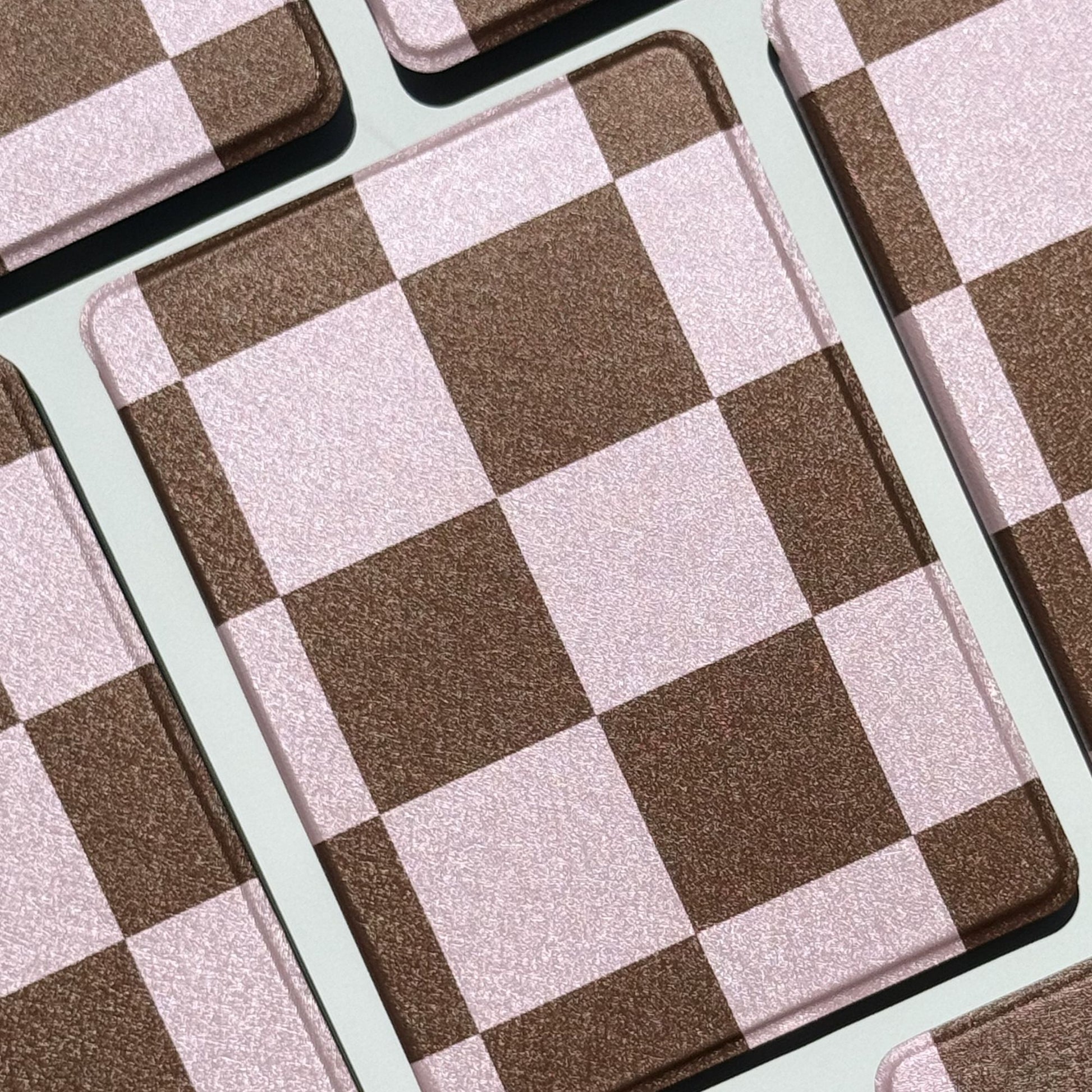 She's Checked In checkered Kindle cases fanned flat showing pink and brown squares