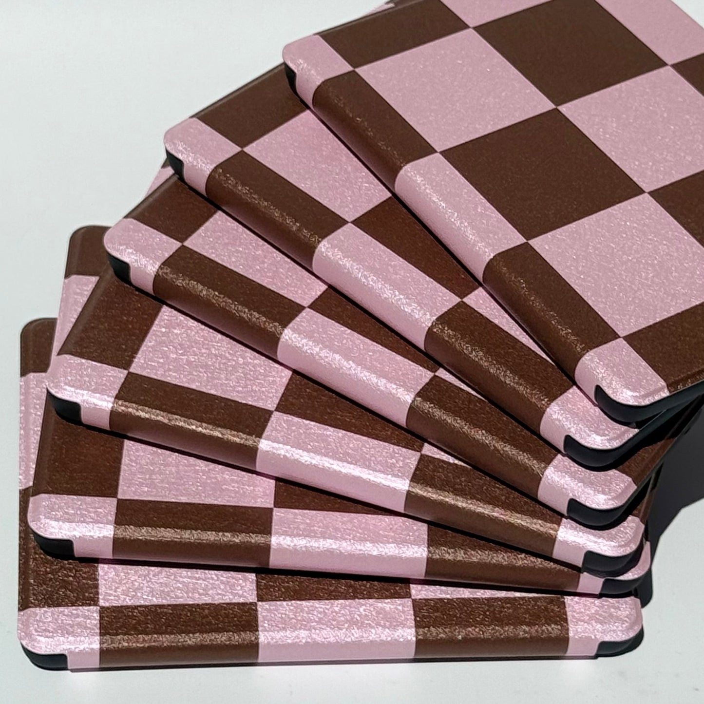 She's Checked In Kindle cases fanned upright showing the aesthetic pink and brown checkerboard