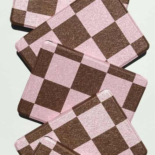She's Checked In pink and brown checkered Kindle cases fanned to show the aesthetic checkerboard — Case Society Co AU