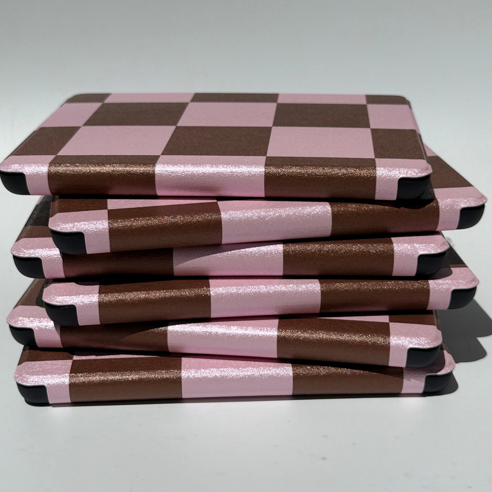 Stack of She's Checked In checkered Kindle cases showing reinforced corners — aesthetic case AU