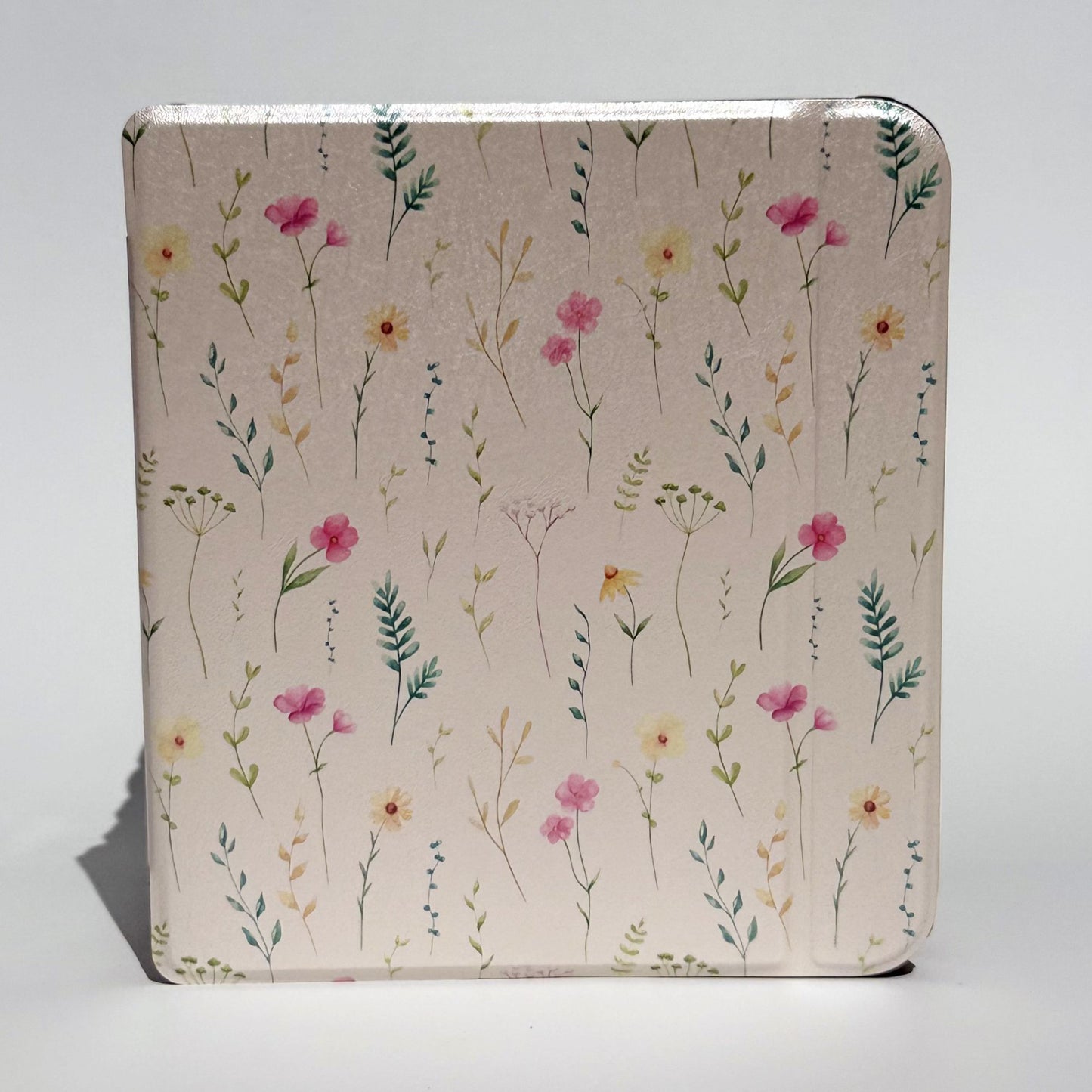 Side profile of Spring Court Kobo Libra cases stacked, cream pressed-flower print spine detail with black shockproof bumper corners