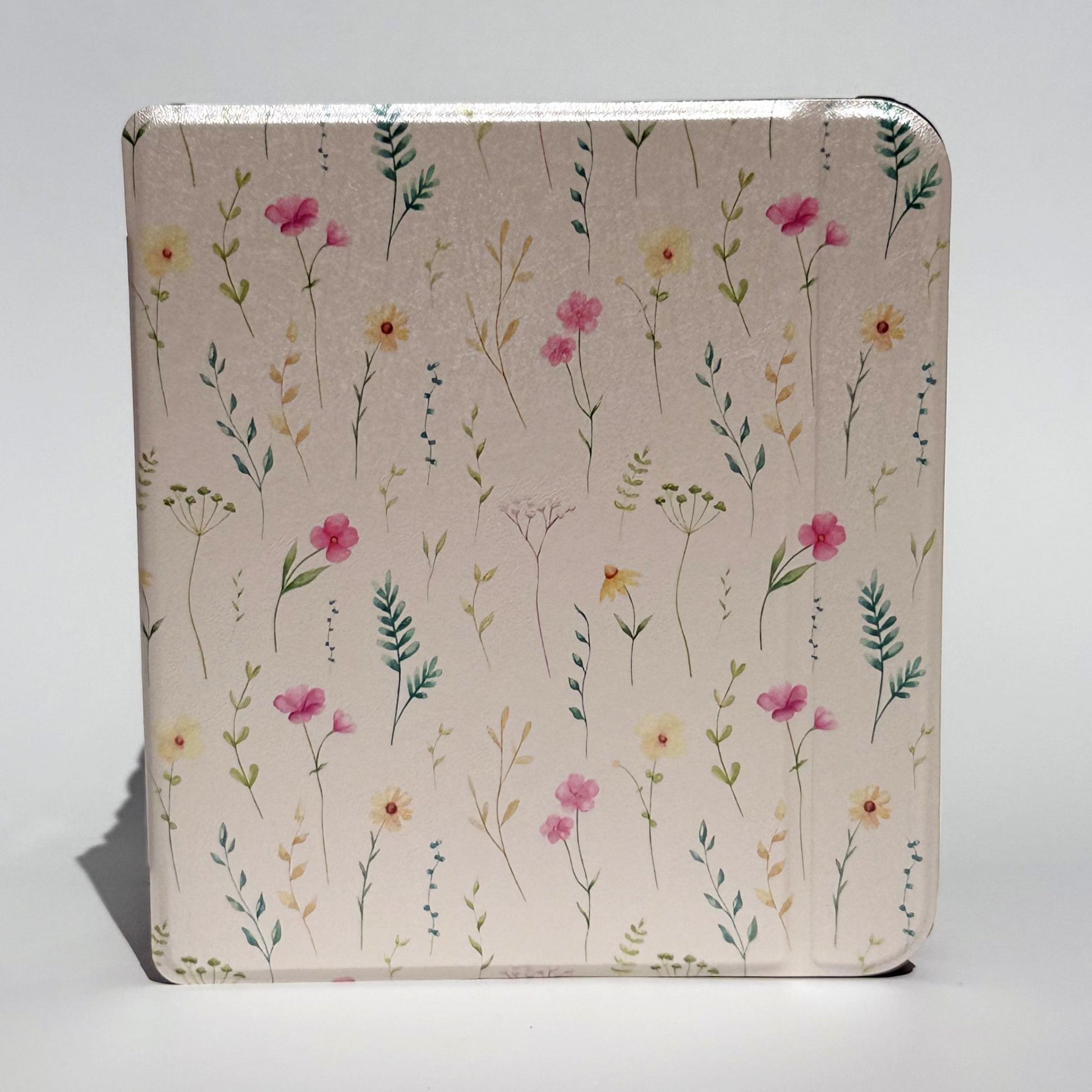 Side profile of Spring Court Kobo Libra cases stacked, cream pressed-flower print spine detail with black shockproof bumper corners