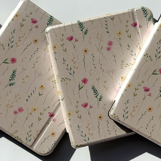 Stack of Spring Court Kobo Libra cases in cream with pressed wildflower print — pink, yellow and white florals with green ferns