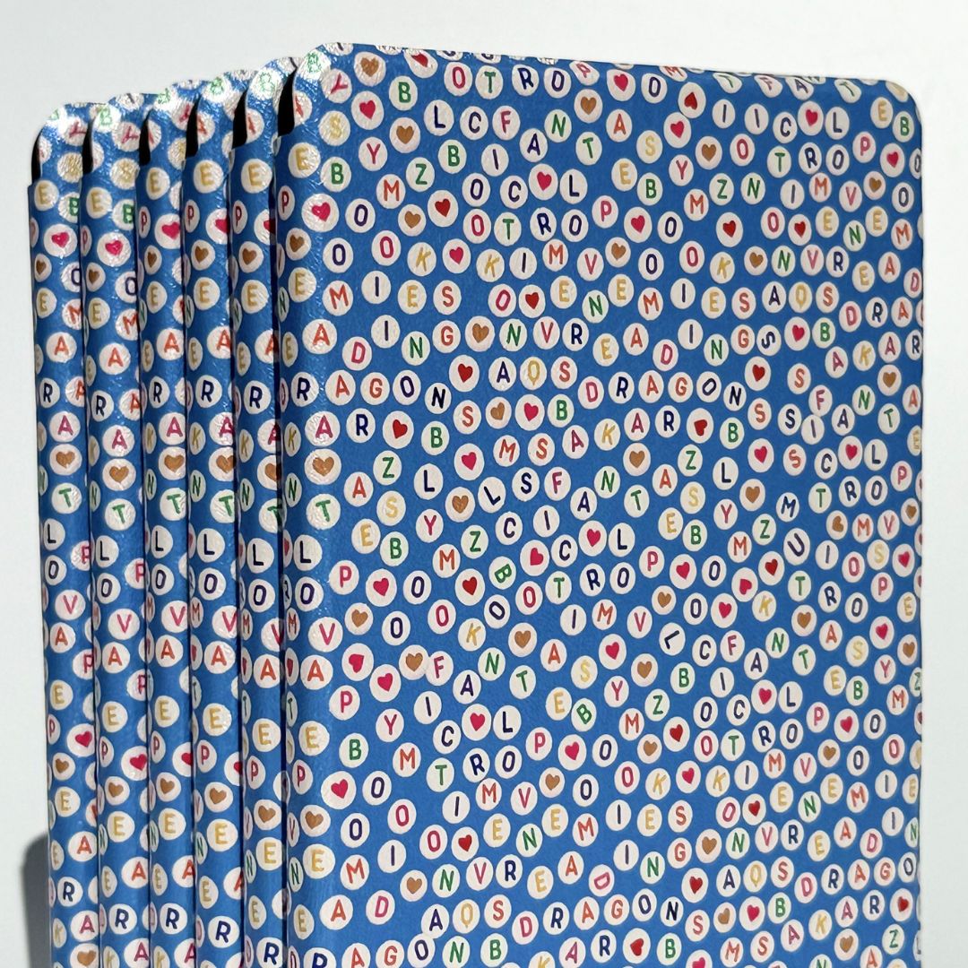 Multiple Swiftly Written Kindle cases in blue with a bookish letter bead print