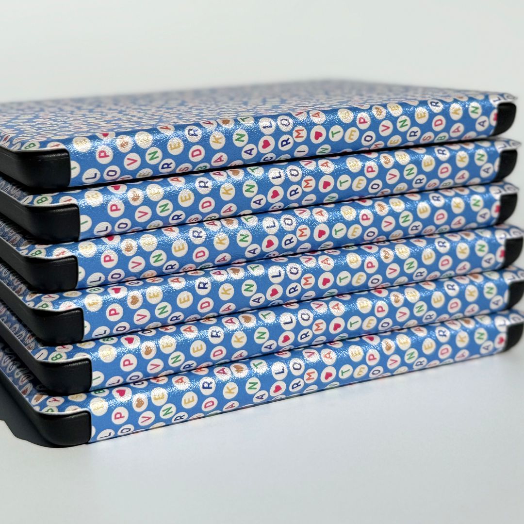 Fanned Swiftly Written Kindle cases showing the blue friendship bracelet bead print