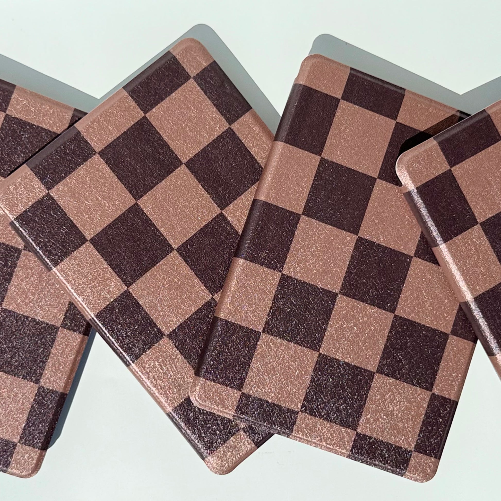 The Dreamer kindle case top view of overlapping cases in chocolate check