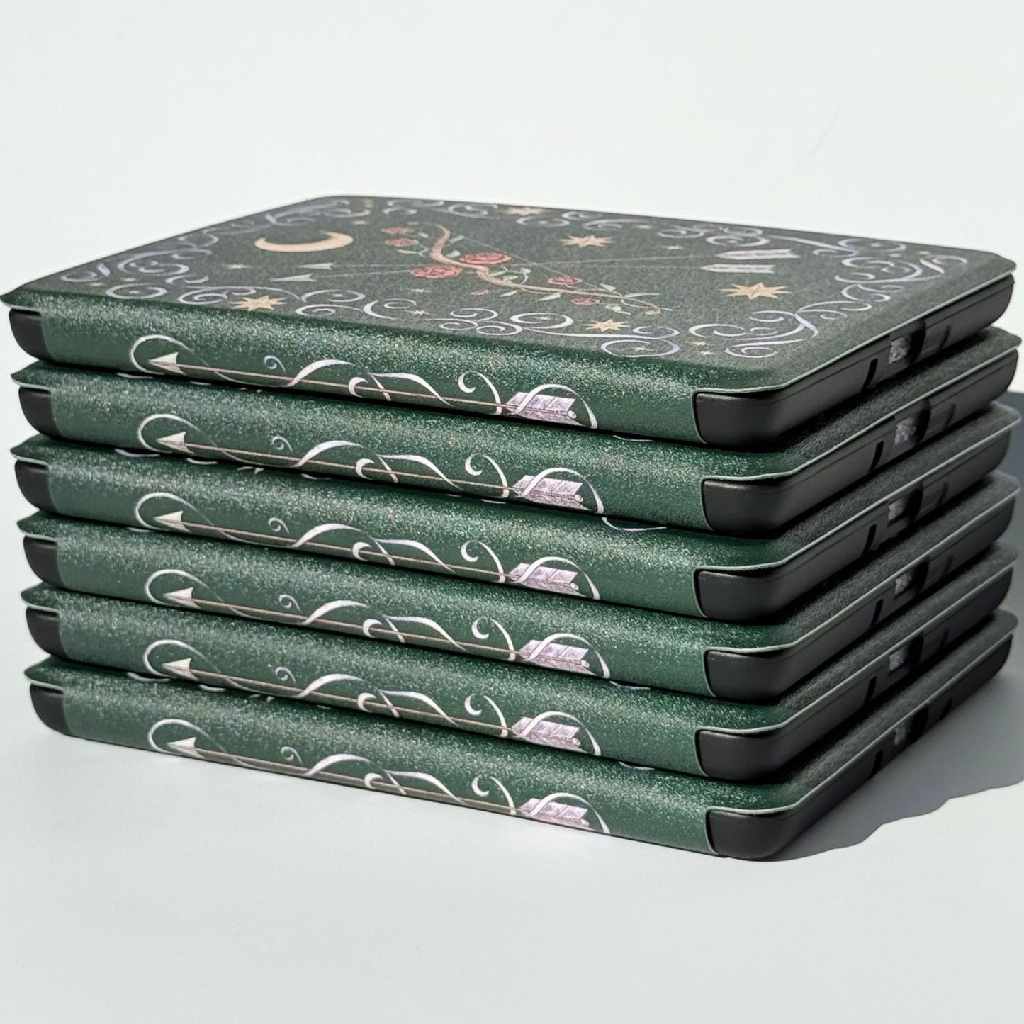 The Huntress Kindle case on a Kindle, emerald green with a rose bow and silver arrows by Case Society