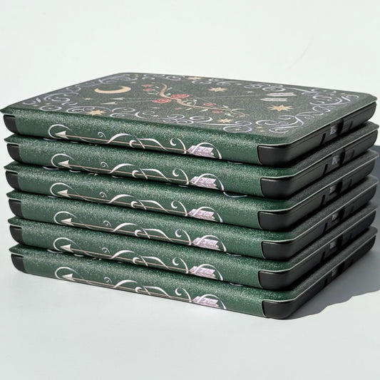 The Huntress Kindle case on a Kindle, emerald green with a rose bow and silver arrows by Case Society
