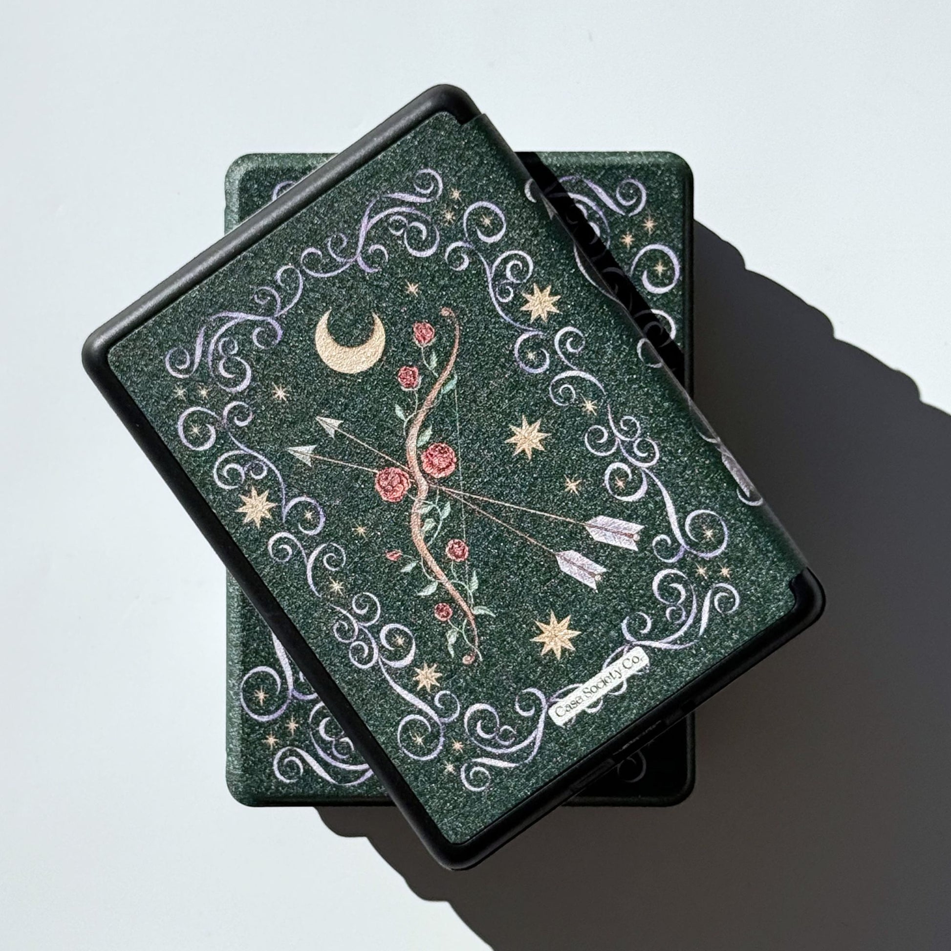 The Huntress Kindle case shown on a Kindle Paperwhite, green with rose bow, Case Society Co