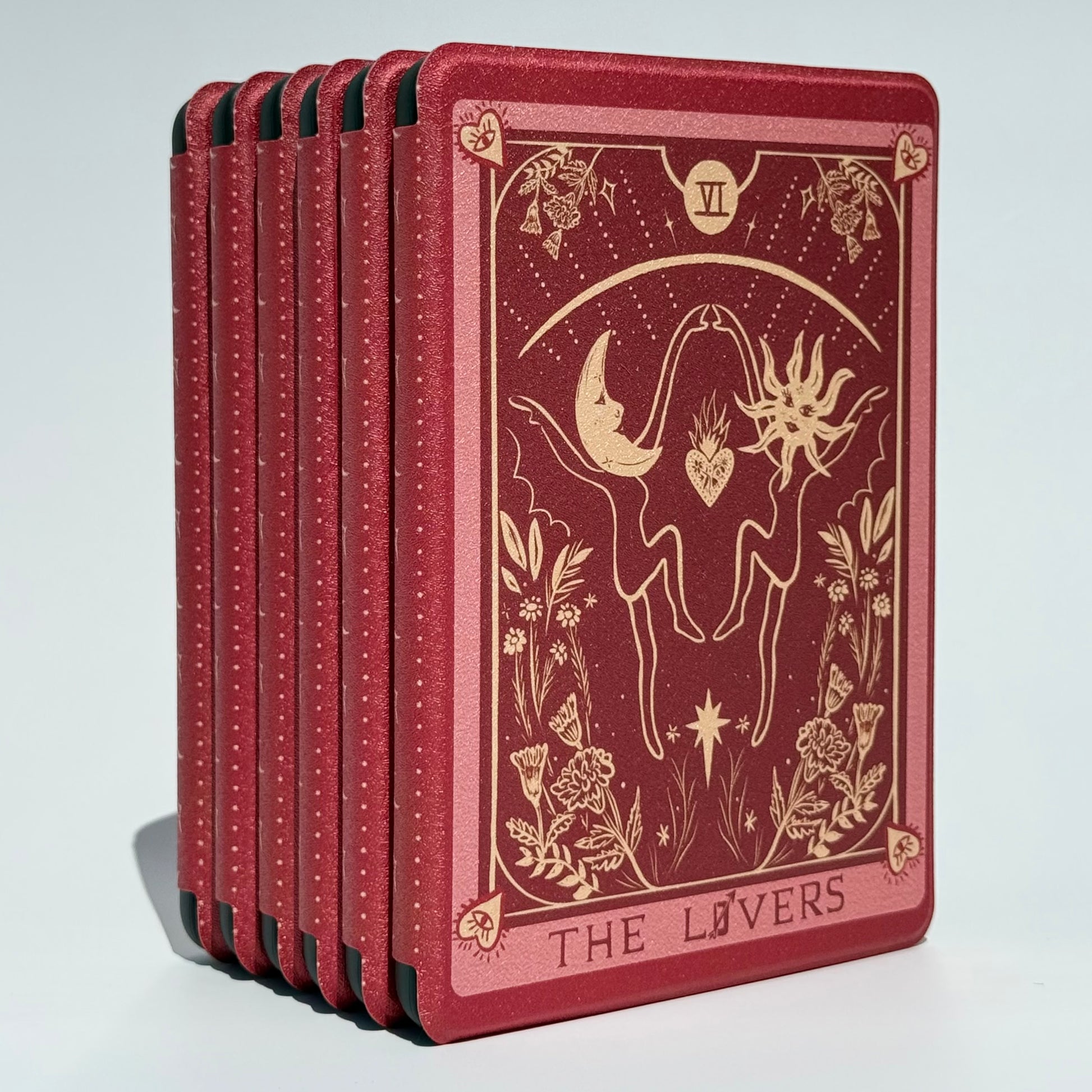 The Lovers Kindle cases standing in a row showing the celestial sun and moon design in antique gold