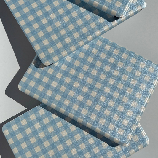 The Quiet Blue blue gingham Kindle cases arranged in a wave showing soft cream check — Case Society Australia