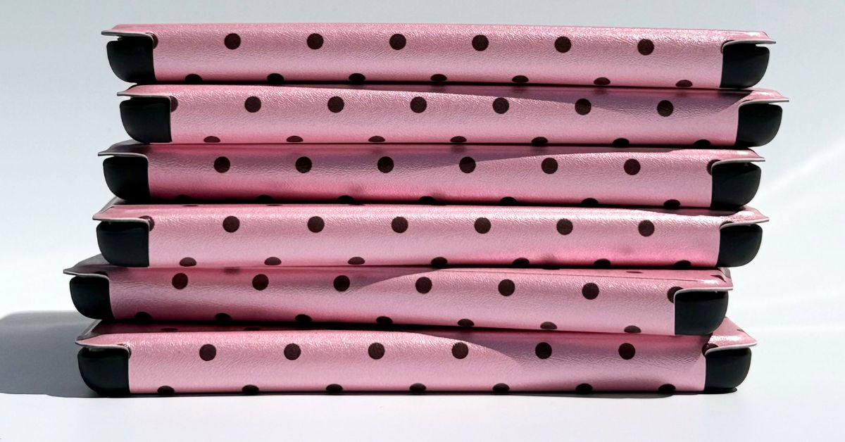 A stack of pink polka dot Kindle cases by Case Society Co, banner for The Reading Room blog