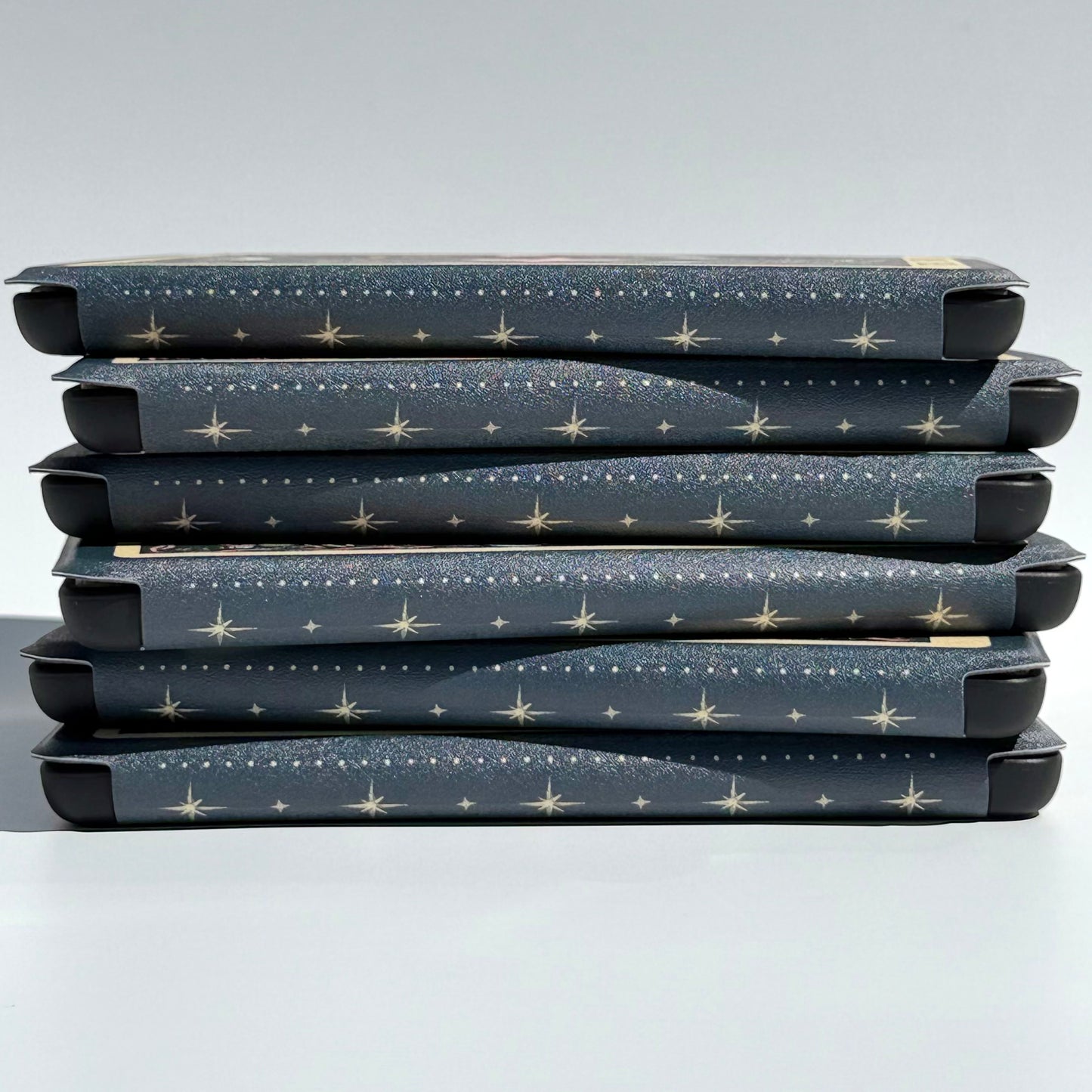 Close up of the celestial dot and star spine pattern across a stack of Kindle cases
