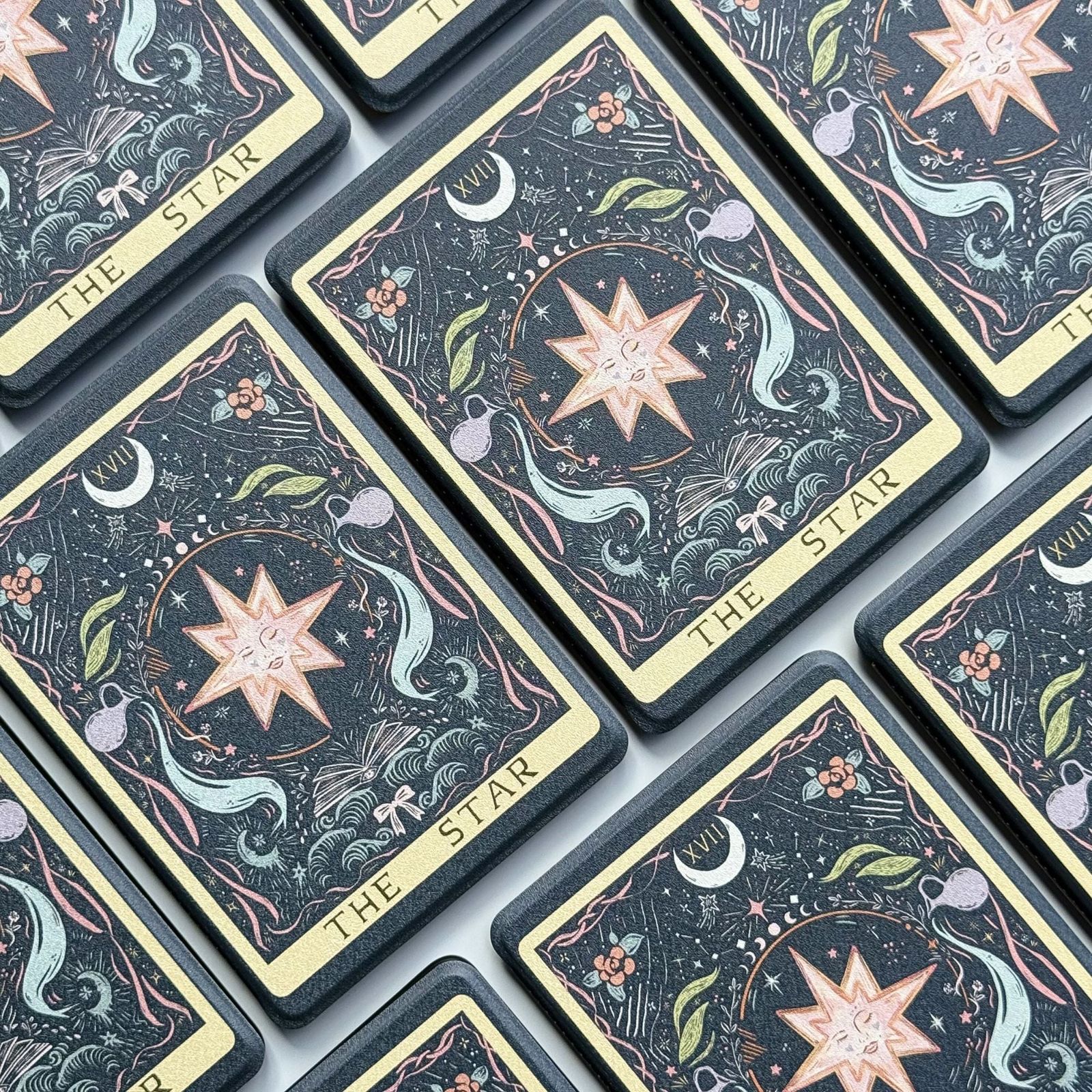 Rows of The Star Kindle cases, tarot card XVII design with cream borders on navy, by Case Society Australia