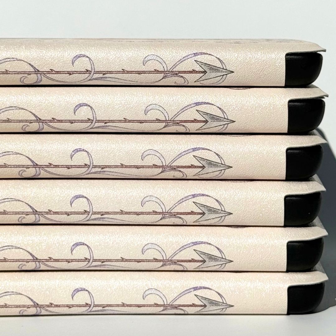 Arrowhead end of the spine on cream romantasy Kindle cases