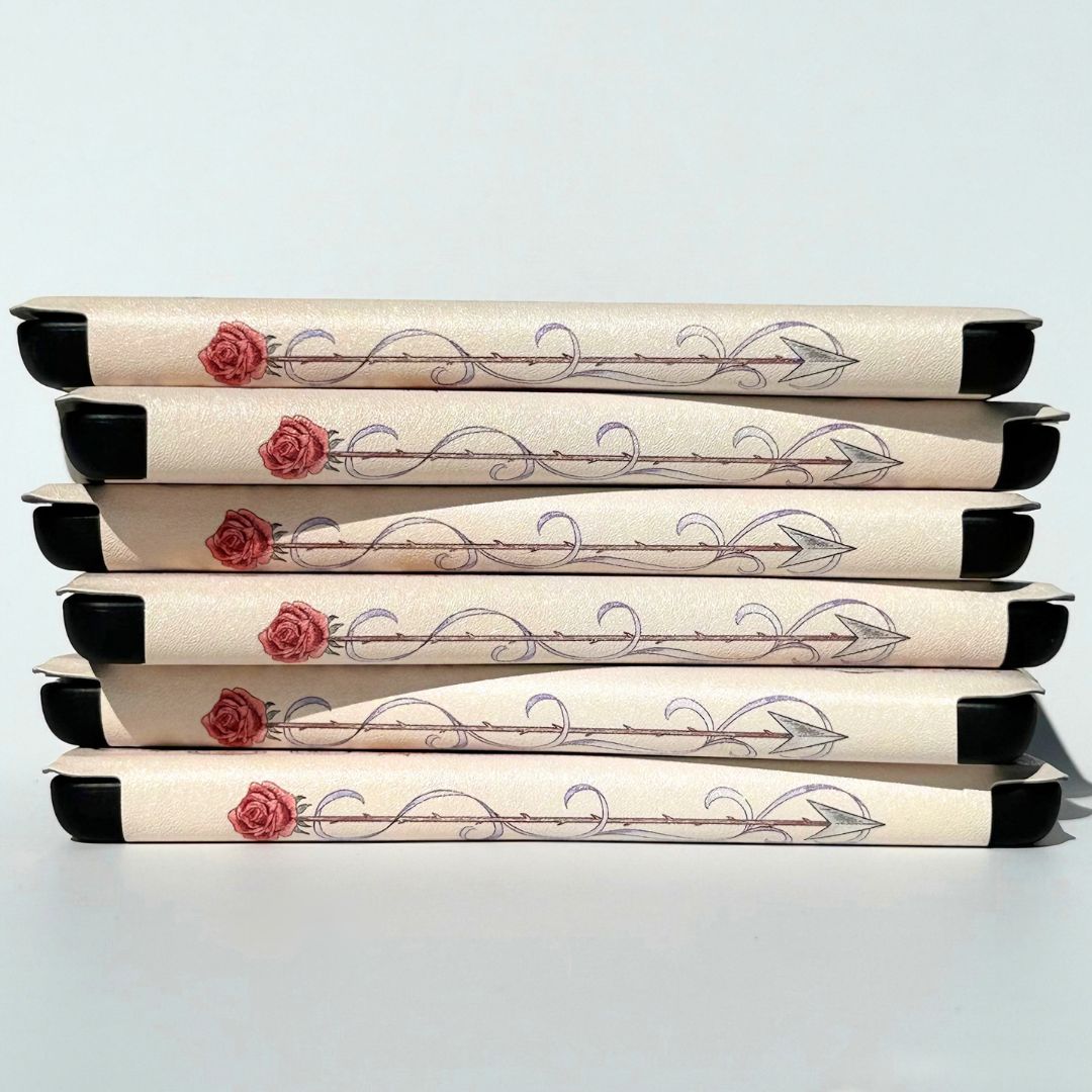 The Vow Kindle cases stacked unevenly, rose and arrow spine detail