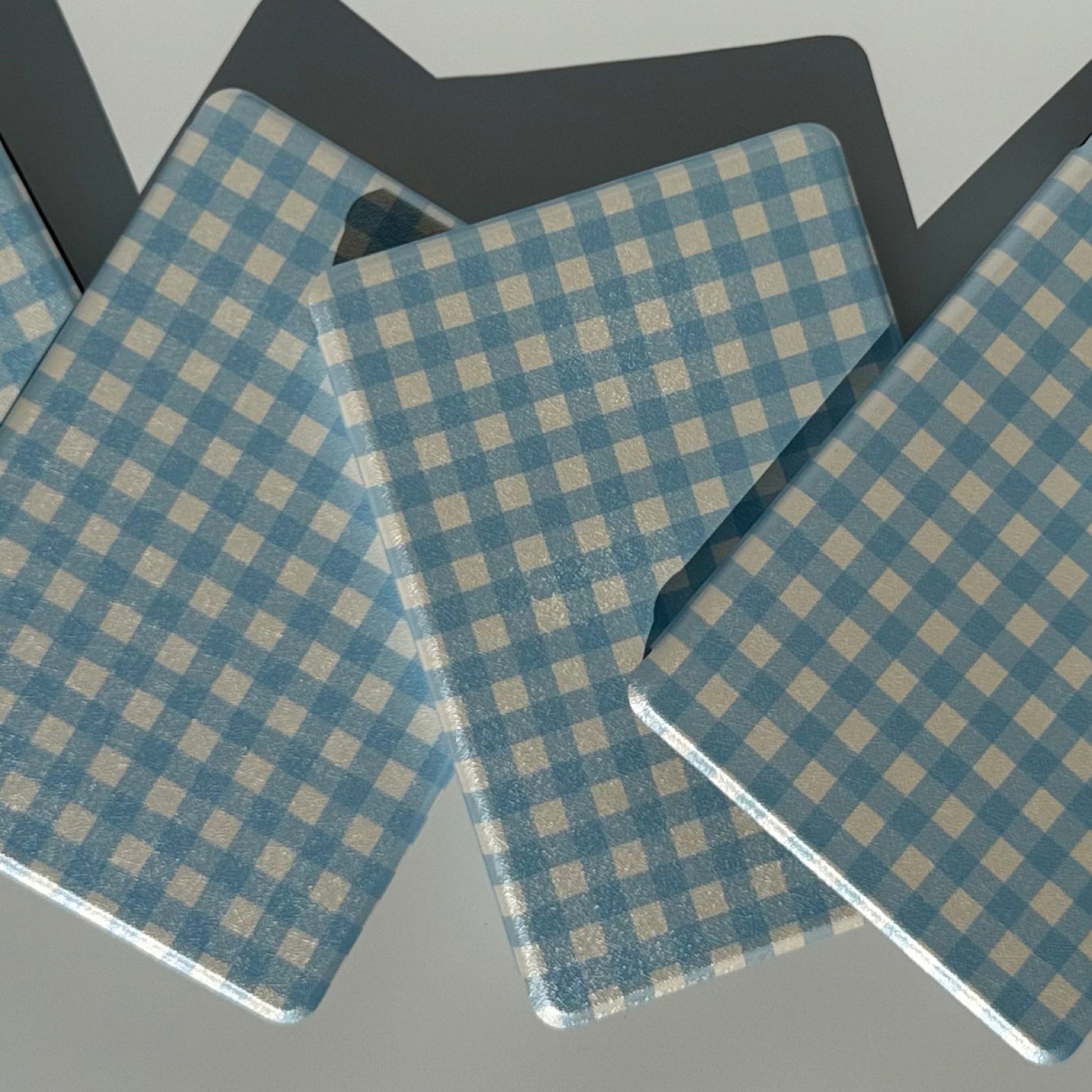 Two The Quiet Blue blue gingham Kindle cases propped at angles showing front and back