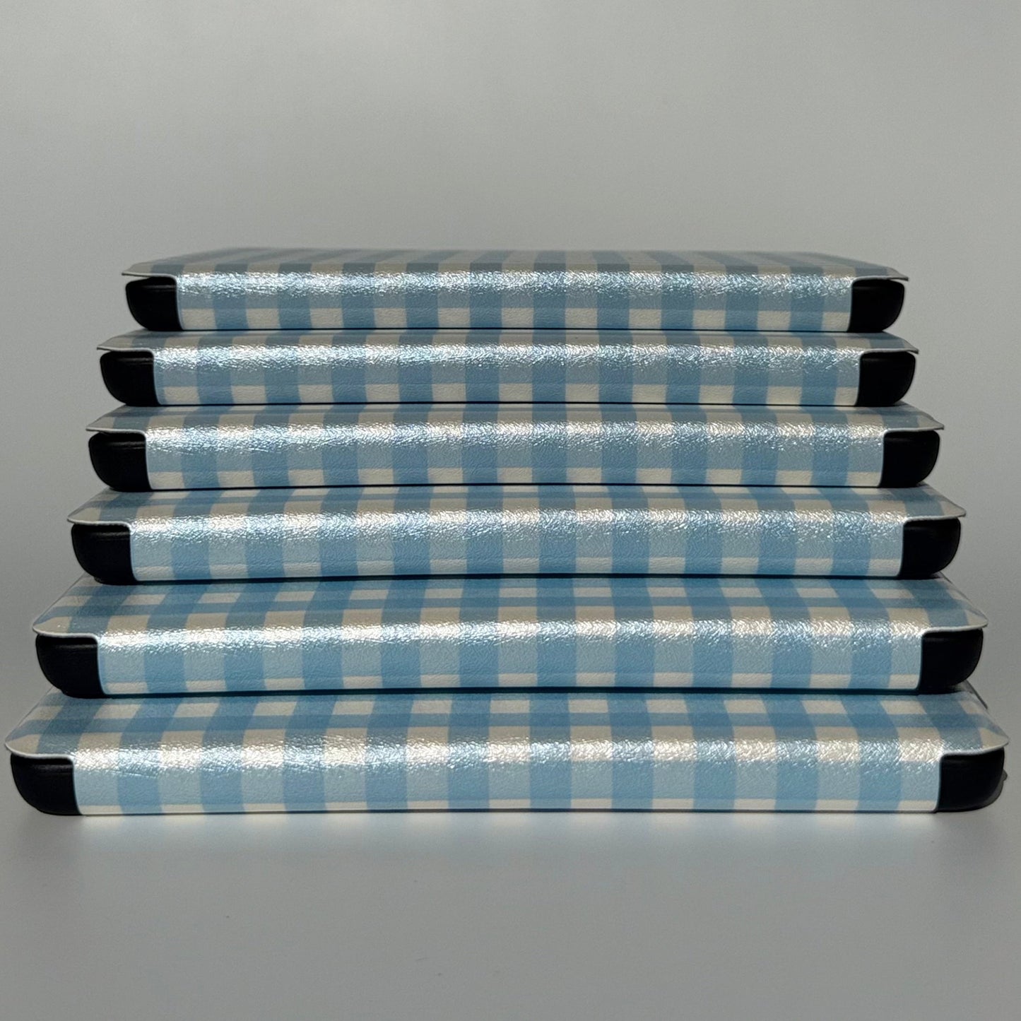 The Quiet Blue Kindle cases stacked flat showing blue gingham check, cottagecore bookish case AU