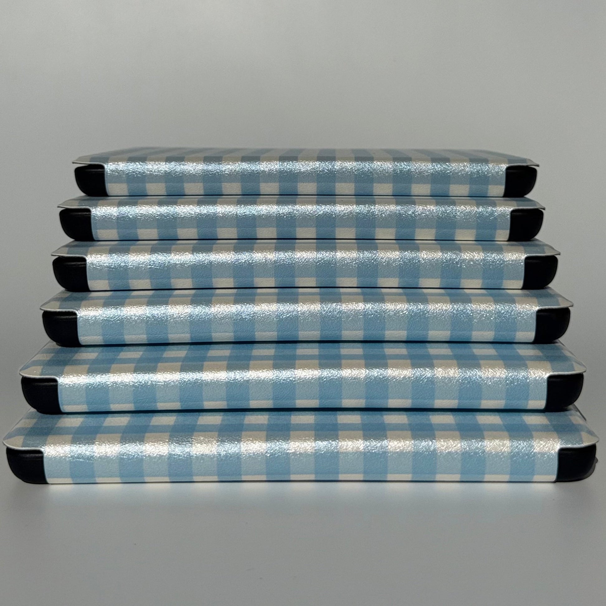 The Quiet Blue Kindle cases stacked flat showing blue gingham check, cottagecore bookish case AU